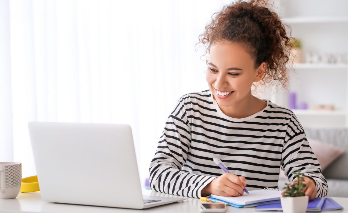 Young woman using laptop for online learning at home